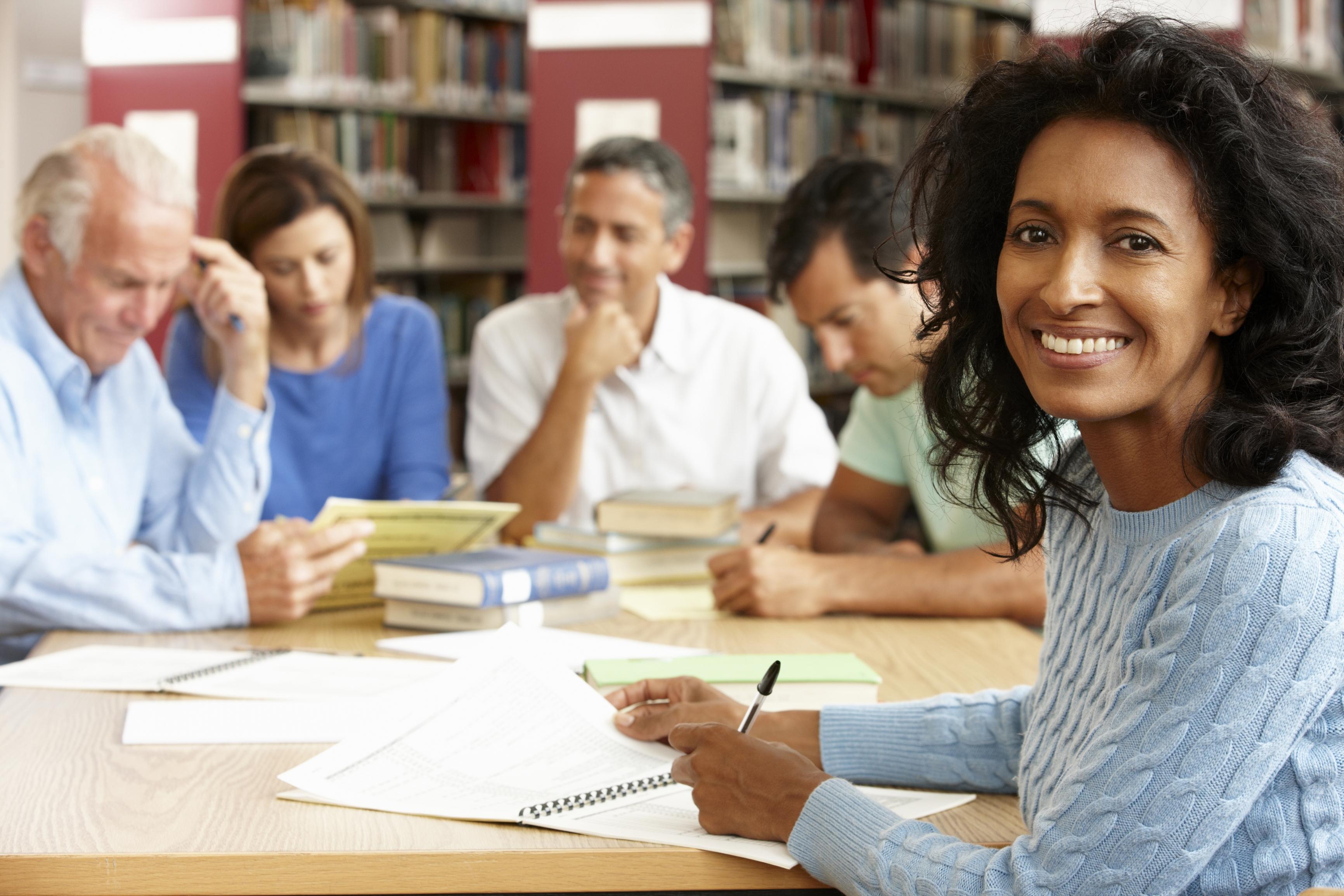 Mixed group of students studying in library